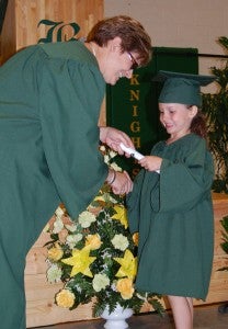Zoey Perry receives her diploma from preschool assistant lead teacher Wendy Spivey. (Photo by Jordan Miles)