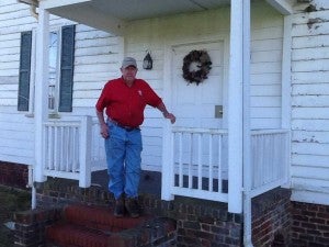 Robert Duncan stands on the front porch of the 200-year-old home his family moved into in 1930. 