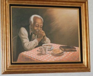 A painting in Holman’s kitchen expresses his view of Piedmont Senior Resources’ home-delivered meals. “They’re a blessing,” he said.