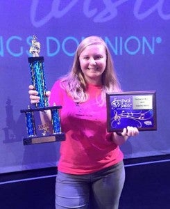 Danielle Neller poses with the first-ever eighth-grade competition band trophy won by Buckingham schools at the Kings Dominion Band Festival of Music in June. The band won second place overall and earned a superior rating. 