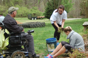 Danny Marsh enjoys visiting with Emma Canfield and Gracie Piekarski as they pull weeds around his pond.