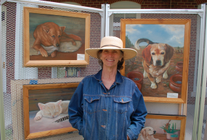 Lee Morrison, of Buckingham, stands among her paintings of animals.