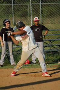 TITUS MOHLER | HERALD Tya Johnson prepares to swing at the oncoming pitch as Caleb Camp, left, and Evan Maliangos look on in the background during the Prince Edward-Farmville Area Summer Baseball Camp.