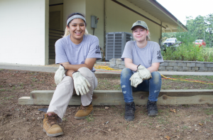 Camila Vargas, left, and Ashley Miller take a break from working on creating a wood-enclosed picnic pad at Twin Lakes State Park. (Photo by Carson Reeher)