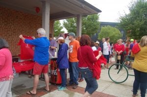 MARTIN L. CAHN | HERALD Folks line up for free soft drinks and T-shirts from Coca-Cola during Saturday's All-American Downtown Festival on Farmville's High Bridge Trail Park plaza.