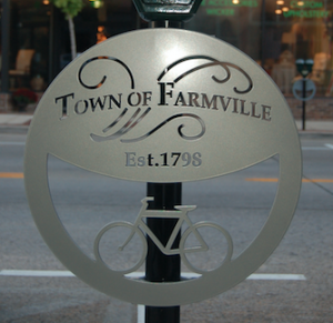MARTIN L. CAHN | HERALD Not a sign, per se, but certainly a sign of the times for downtown Farmville: one of 11 new bicycle hoops recently installed on parking meters. The hoops are both decorative and informative, acknowledging the town’s establishment in 1798.