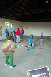 MARTIN L. CAHN | HERALD A child dressed as a Teenage Mutant Ninja Turtle attempts to knock down the last pin in a game of bowling during New Life Church’s Fall Fest on Friday afternoon as other children play other games nearby.