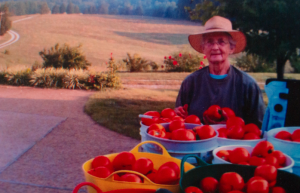An old photograph of Katrena Young posing with buckets of tomatoes in a truck bed that she and her husband, Tom, gave to FACES.