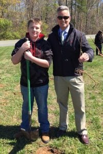 Student Tyler Sage, left, and Superintendent Dr. Cecil Snead plant a tree as a part of Buckingham County’s Green Initiative.