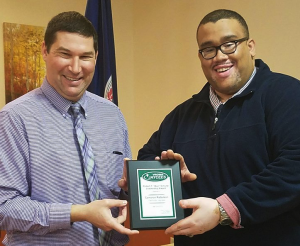 Cam Patterson receives the Robert F. “Buz” Schultz Leadership Award from Jeffrey Gore, left.