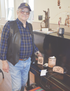 Ramon Stafford stands next to three leatherworking pieces he brought with him to the exhibit.